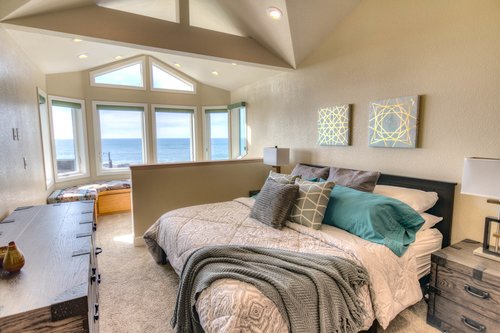King bed in upstairs bedroom with a sitting area to enjoy the views.